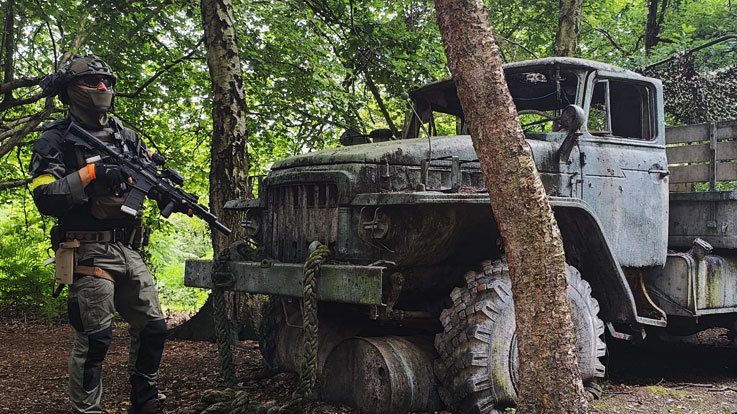 airsofter hiding behind military truck